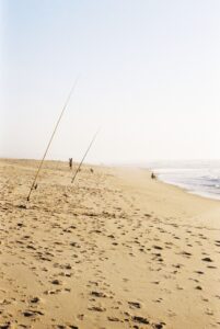 Cañas de surfcasting clavadas en la arena de una playa