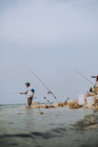 Pescadores lanzando la caña desde la orilla del mar