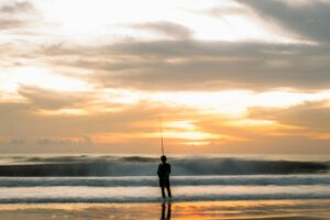 Pescador en la playa al atardecer